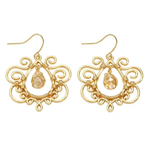 Gold filigree teardrop crystal hook earrings boho dangle jewelry close-up view.