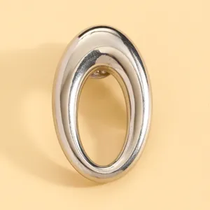 Silver metallic oval glasses brooch detail shot, minimalist design, elegant accessory for women.
