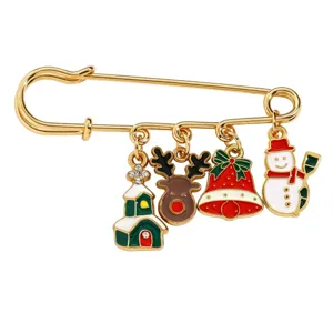 Nahaufnahme eines goldenen Weihnachts-Sicherheitsnadel-Broschen mit süßen Emaille-Anhängern.