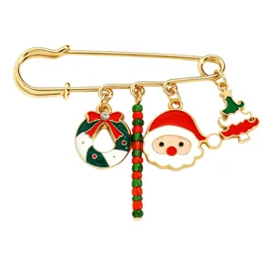 Nahaufnahme einer goldenen Sicherheitsnadel Brosche mit bunten Weihnachtsmotiven.