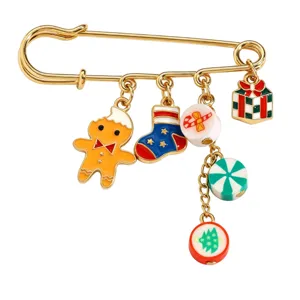 Nahaufnahme einer goldenen Sicherheitsnadel-Brosche mit süßen Weihnachts-Emailelementen.