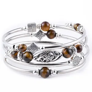 Mehrlagiges Wickelarmband aus Metallreifen mit braunen Natursteinperlen und floralen Anhängern.
