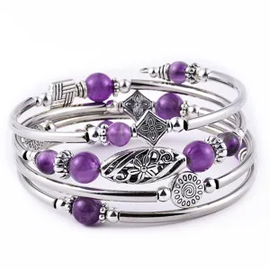Elegantes mehrlagiges Wickelarmband mit violetten Perlen und antiken Silberanhängern.
