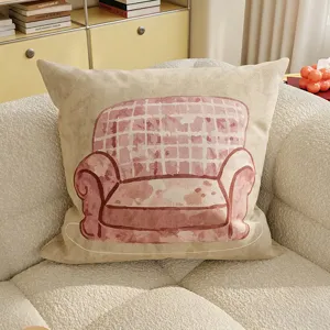 Gros plan détaillé du coussin beige avec une jolie illustration de canapé rose.