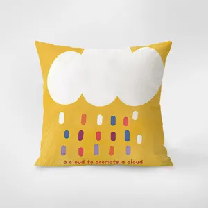 Detail d'un coussin en velours jaune avec un motif de nuage blanc et de gouttes.