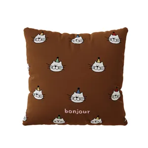 Detalle de cojín gato marrón, tierno diseño gatito gorro fiesta, funda cojín sofá suave.