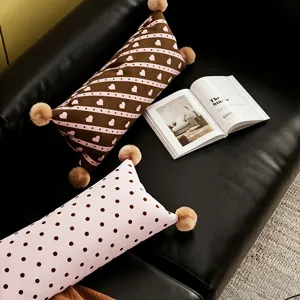 Vue détaillée du coussin lombaire long avec motif à pois et cœur mignon, pompons.
