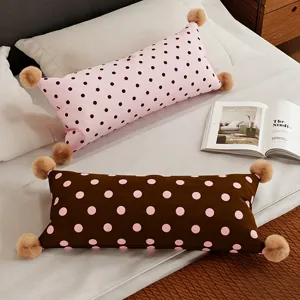 Vue détaillée du coquin lombaire long avec design de pois et pompons pour le lit.