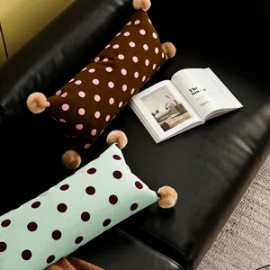 Coussin lombaire à pois doux avec pompons moelleux, idéal pour le canapé et la chambre à coucher.