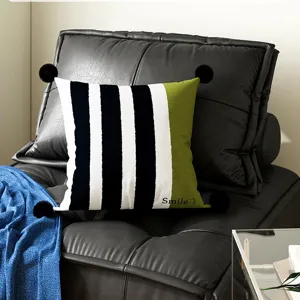 Striped throw pillow with green block and pom-poms, perfect for sofa and bed decoration.