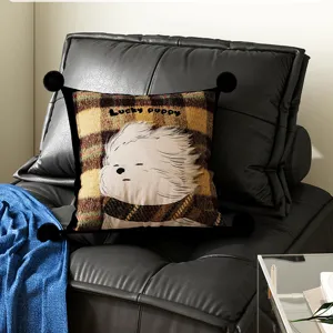 Detailed view of a charming cartoon puppy plaid throw pillow featuring black pom-poms on sofa.
