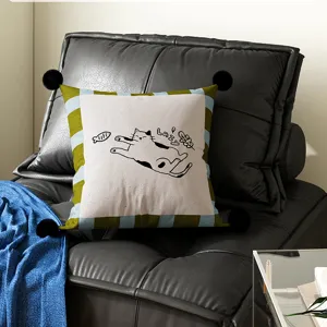 Detailed view of the cute cartoon cat pattern decorative pillow with black pom-poms.