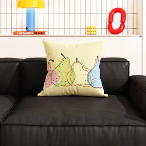 Detailansicht eines farbenfrohen Kissens mit Birnenmuster auf einem modernen Ledersofa.