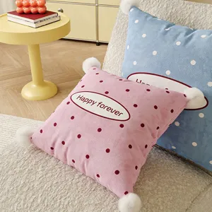 Soft polka dot throw pillow with cute pom poms for living room sofa and bedroom bed decor.