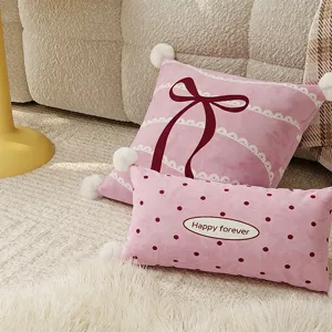 Pink plush throw pillow detail featuring cute bow and polka dot patterns for cozy living room sofa.