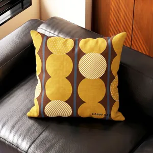 Detalle del cojín con círculos amarillos y rayas geométricas sobre tela marrón retro.
