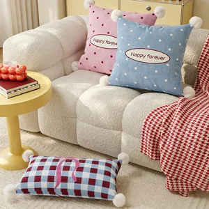 Cozy plush throw pillow detail shot, soft polka dot cushion with cute pom-pom trim for sofa.