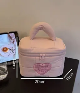 Pink quilted cosmetic bag with handle and sweet heart embroidery for travel and daily storage.