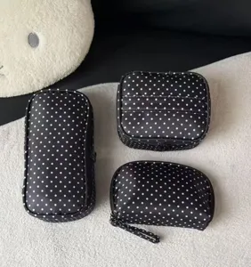 Detailed view of black polka dot cosmetic bags set, portable travel storage toiletry bags.