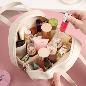 Vue détaillée d'une trousse de maquillage beige en coquille avec compartiments multiples.