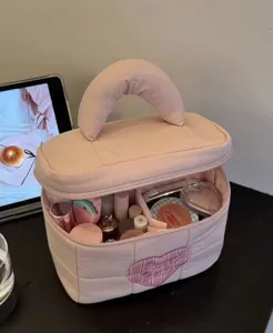 Pink quilted cosmetic bag with heart patch, large capacity portable makeup storage travel organizer.