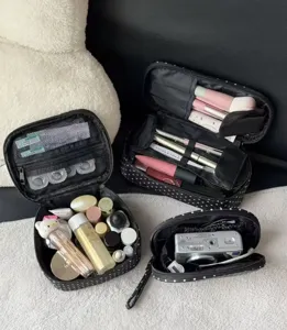 Detailed view of large capacity black polka dot makeup bag with multi compartments for travel.