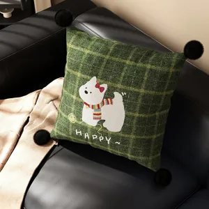 Close-up detail of green plaid throw pillow featuring cute white dog and black pom-poms.