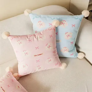 Cozy aesthetic plush throw pillow with cute cartoon rabbit pattern and pom-pom corners for sofa.