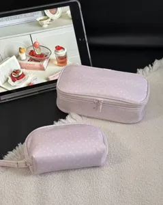 Detailed view of the pink polka dot cosmetic bags set, showing fabric texture and zippers.