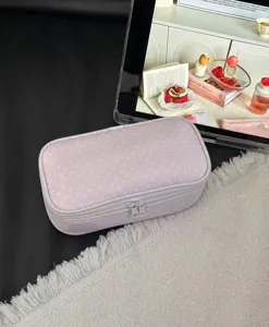 Close-up detail of the pink polka dot cosmetic pouch, showcasing soft fabric and neat double zippers.