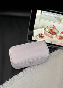 Pink polka dot cosmetic bag detail, soft fabric, durable double zippers, travel makeup pouch.
