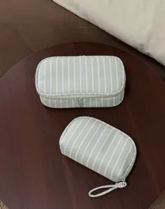Close up view of the striped cosmetic bags, showcasing the durable fabric material and zipper.
