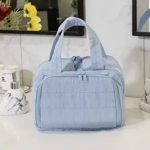 Light blue quilted cosmetic bag, multi-compartment travel organizer with dual zippers.