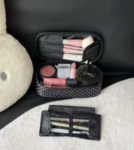 Detail view of black polka dot cosmetic bag interior with brush holders and large storage capacity.