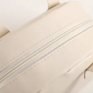 Gros plan détail de la trousse de maquillage beige avec fermeture éclair et texture cuir