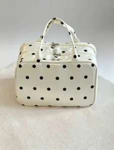 Vista dettagliata della borsa per cosmetici a pois multistrato con cerniera e manico.