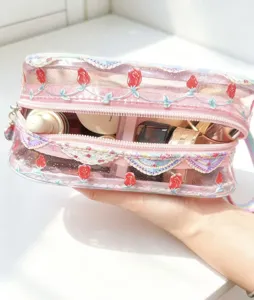 Clear close-up of transparent PVC cosmetic bag with rose pattern and large capacity for travel storage.