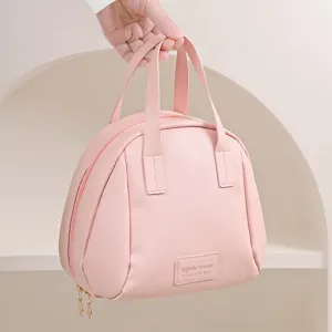 Detail trousse de maquillage coquillage rose, grand sac de voyage avec poignees portables.