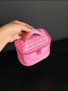 Pink striped cosmetic bag with handle, portable makeup pouch for daily travel use.