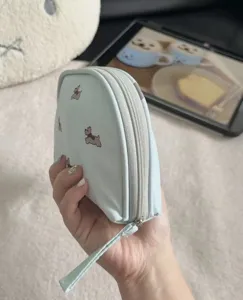 Light blue portable travel cosmetic pouch with cute dog prints, multi-functional mini storage bag.