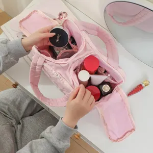 Large capacity pink cosmetic bag, portable travel organizer with compartments and zipper.