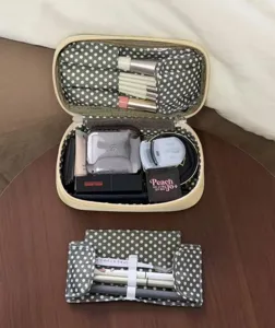 Detailed view of large capacity cosmetic makeup bag with polka dot compartments and brush slots.