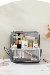 Large capacity travel makeup bag with multiple compartments and brush holders for use.