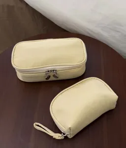 Detailed view of yellow cosmetic bags set, portable travel makeup storage pouches with smooth zippers.