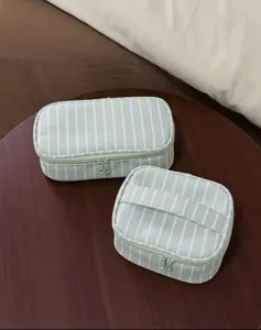Green and white striped cosmetic bag, detail of storage pouch and portable toiletry case.