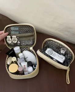 Yellow cosmetic bag detail showing multi-compartment interior storage for travel makeup.