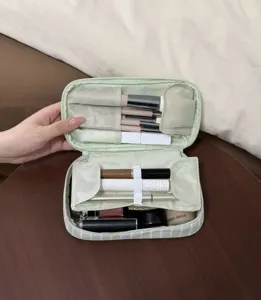 Green and white striped makeup bag with multiple storage compartments for daily use.