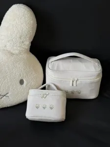 Set of two white canvas cosmetic bags with cute floral embroidery, portable travel makeup case.