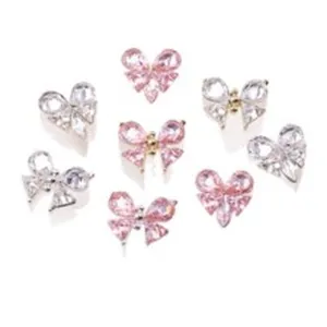 Vue détaillée de strass pour ongles en zircone rose et transparent en forme de nœud, alliage.