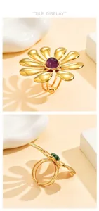 Primo piano dell'anello floreale oversize con petali dorati lucidi e pietra centrale.